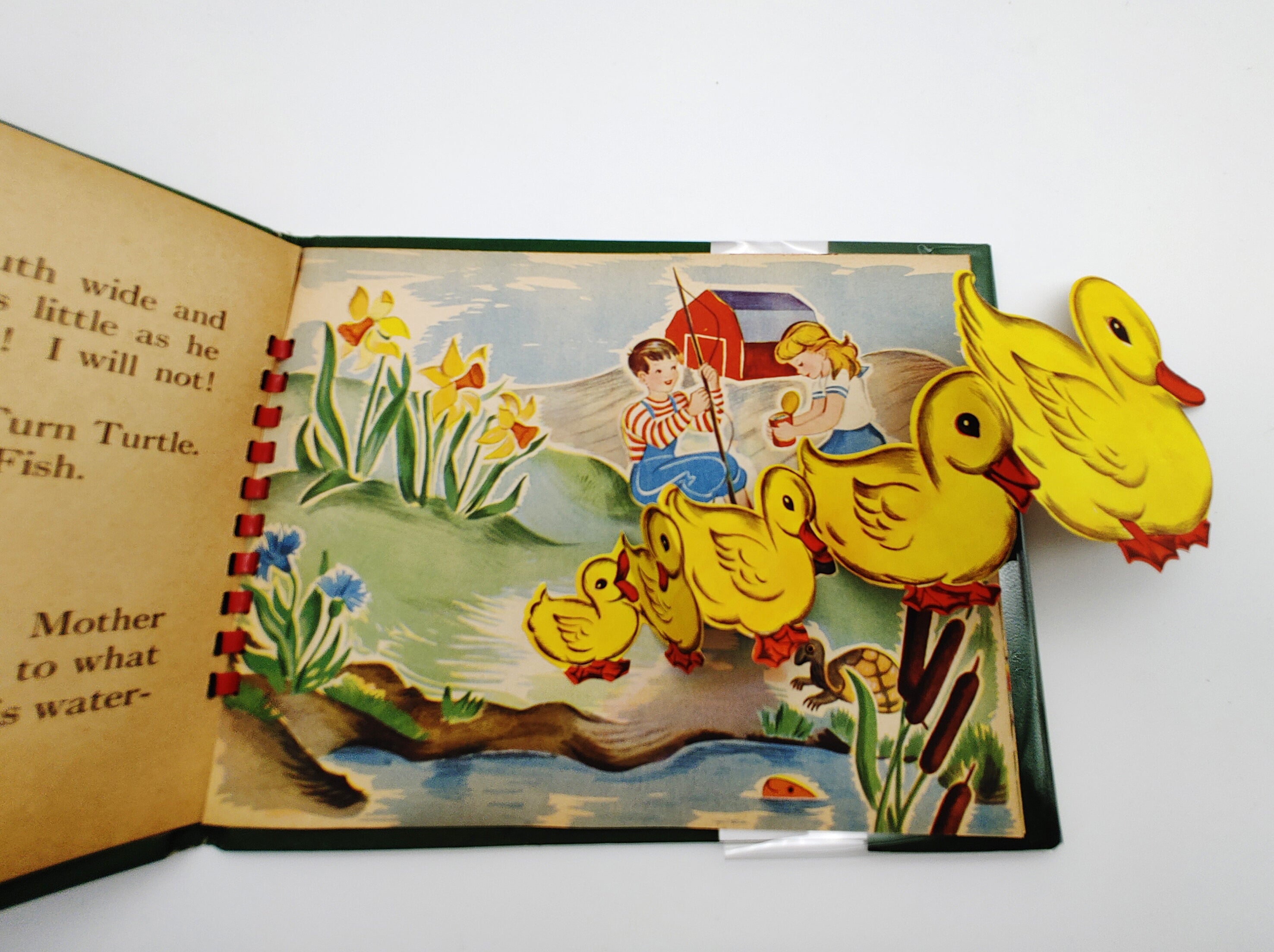 Pop-up book illustration of a series of ducks in a pond where two children are fishing.