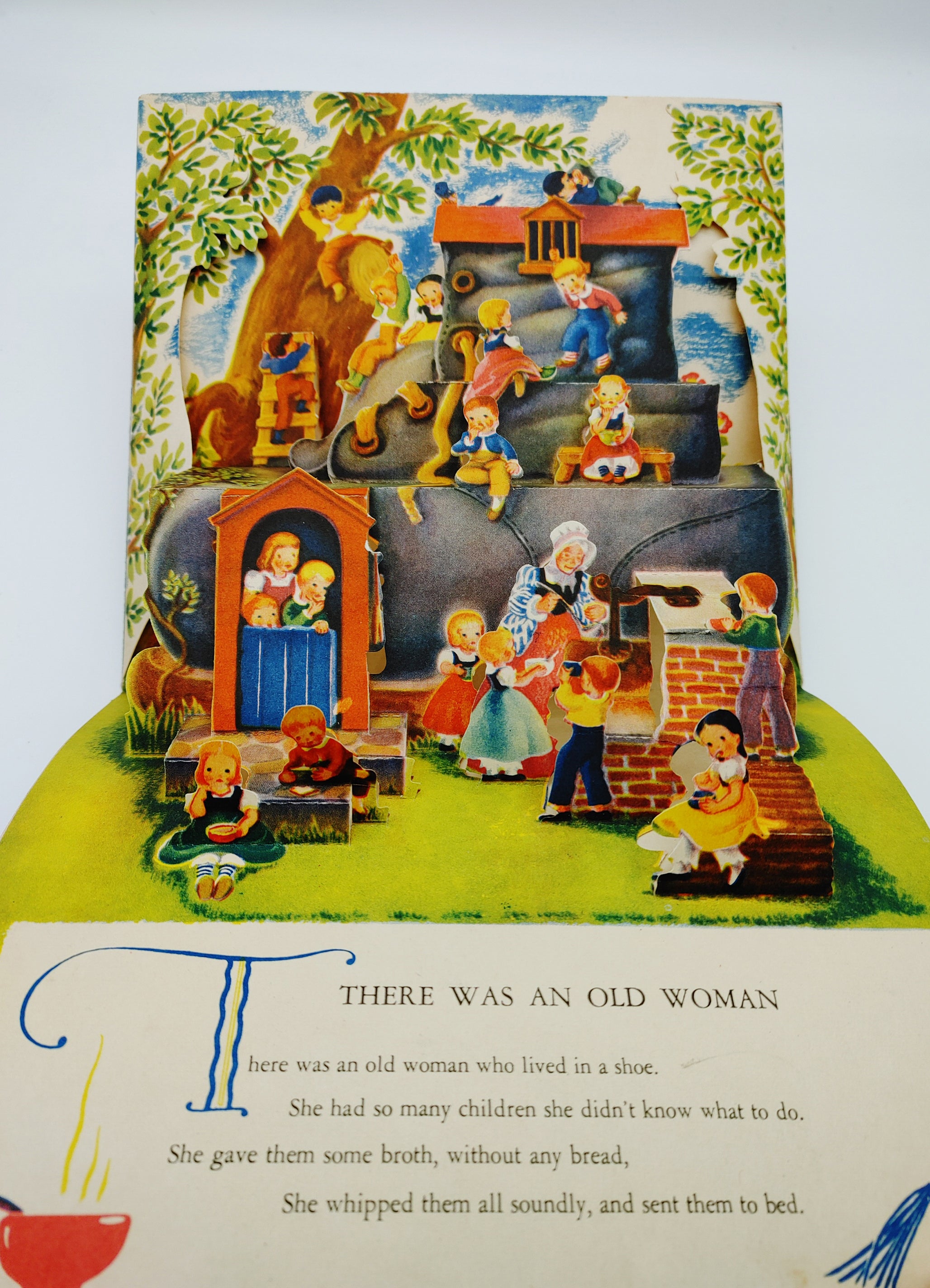 Pop-up illustration of the old woman who lived in a shoe and her many children from Geraldine Clyne's There Was An Old Woman (circa 1938-53)