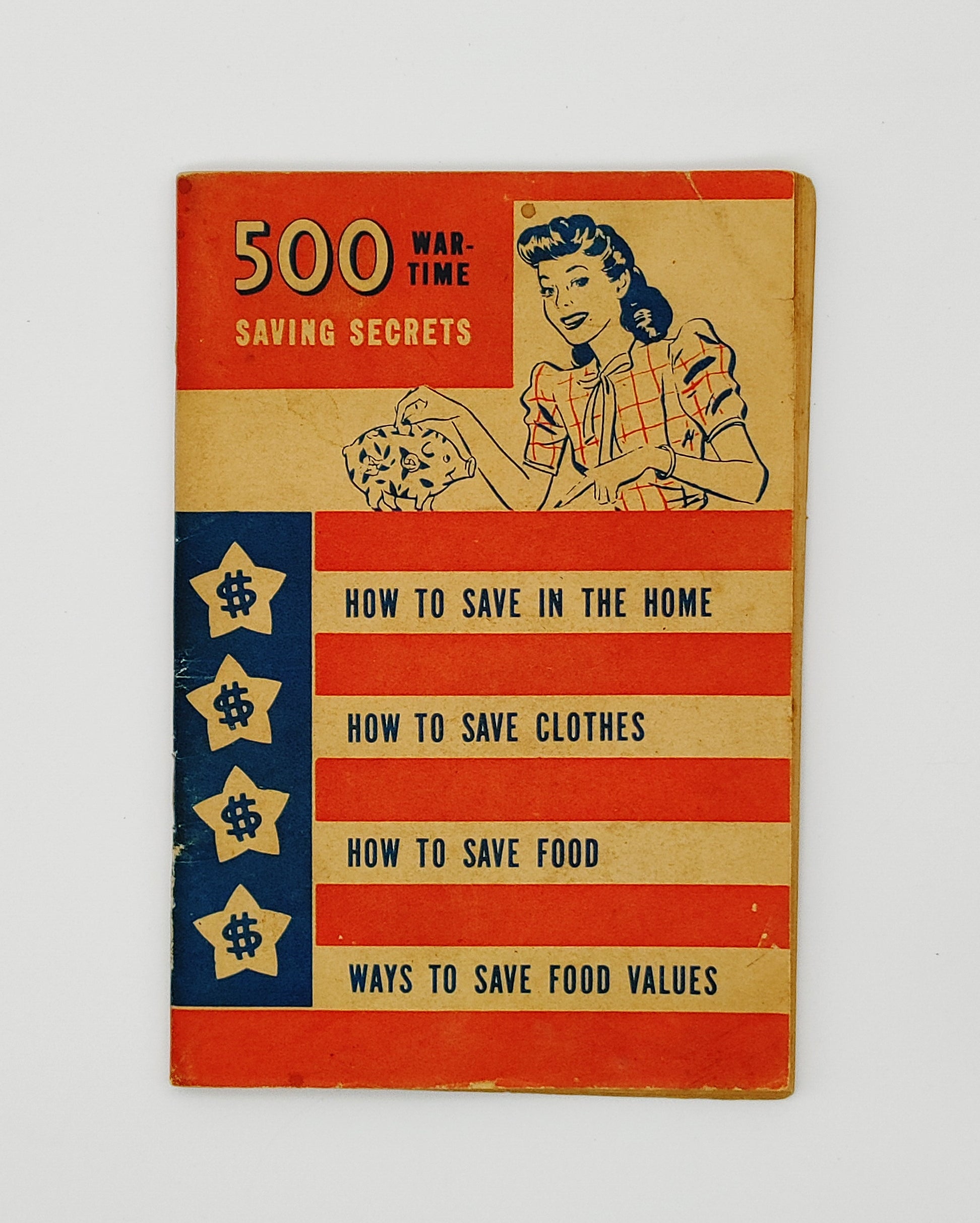 Patriotic flag-themed cover of 500 War-Time Saving Secrets featuring a 1940s woman putting a coin in a piggy bank